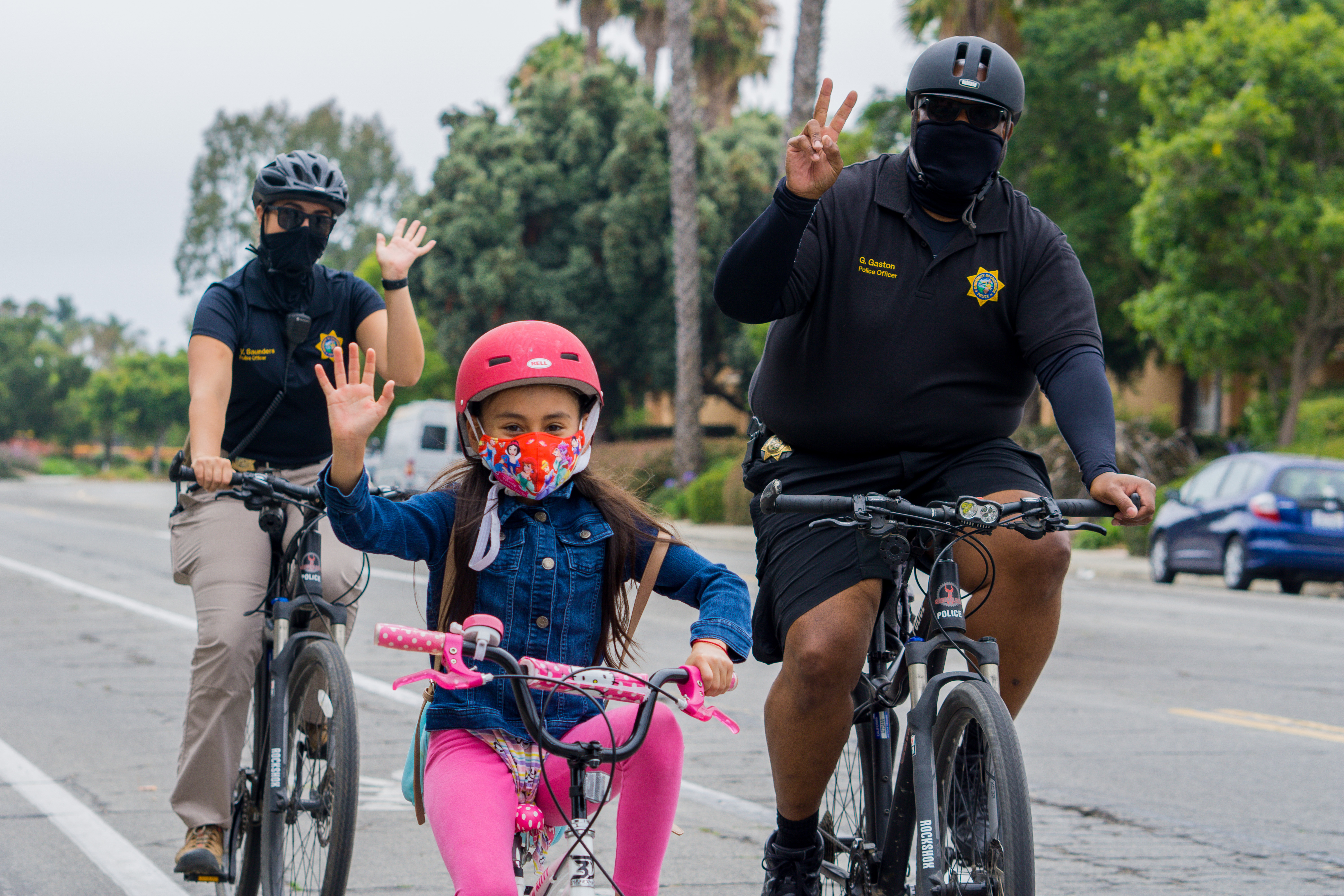 UCSB Police Officers on a socially distanced bike ride with a child